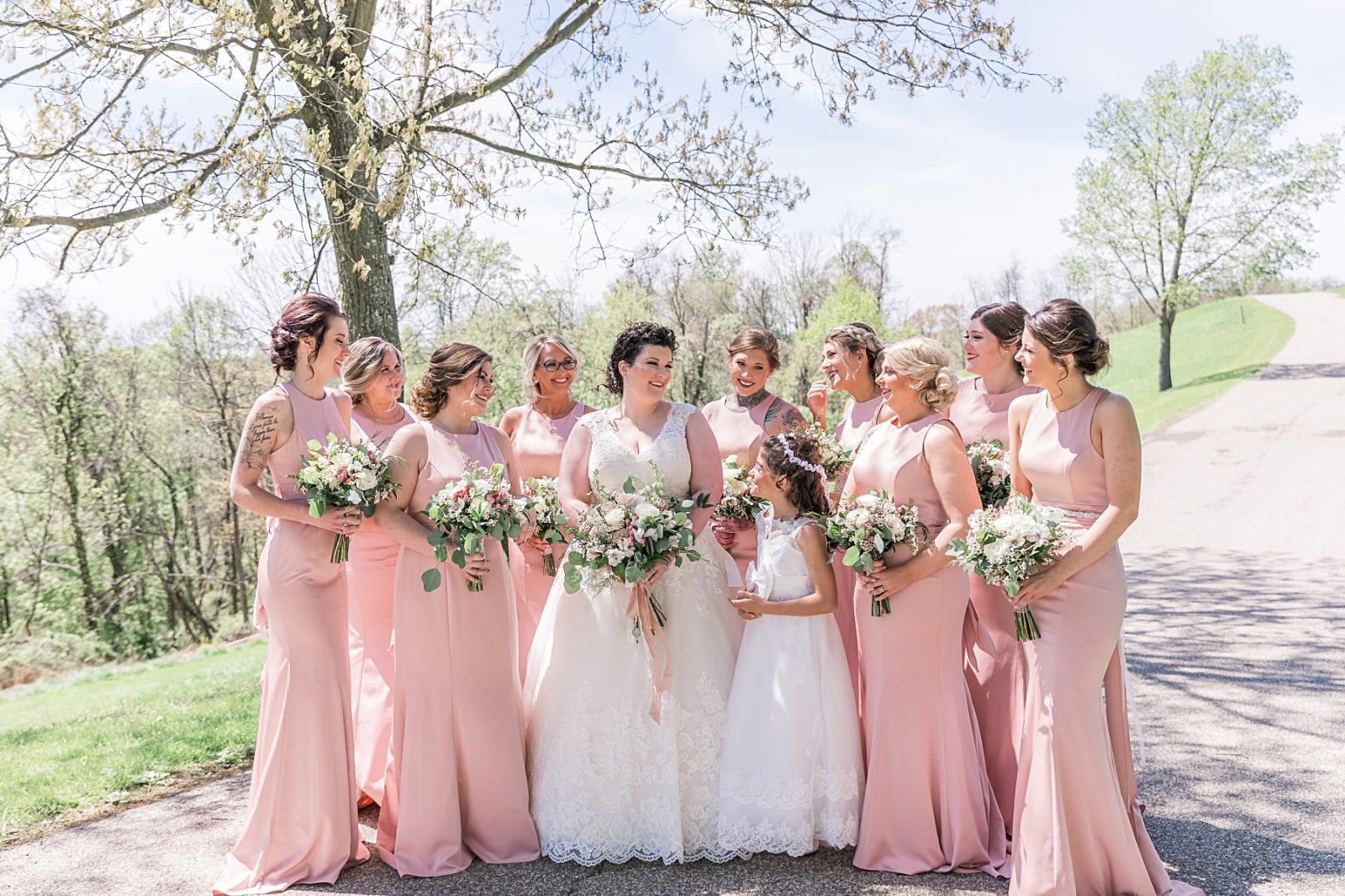 Wedding photography by Diana Gramlich, Bride with bridesmaids in blush Allure dresses looking at each other and smiling