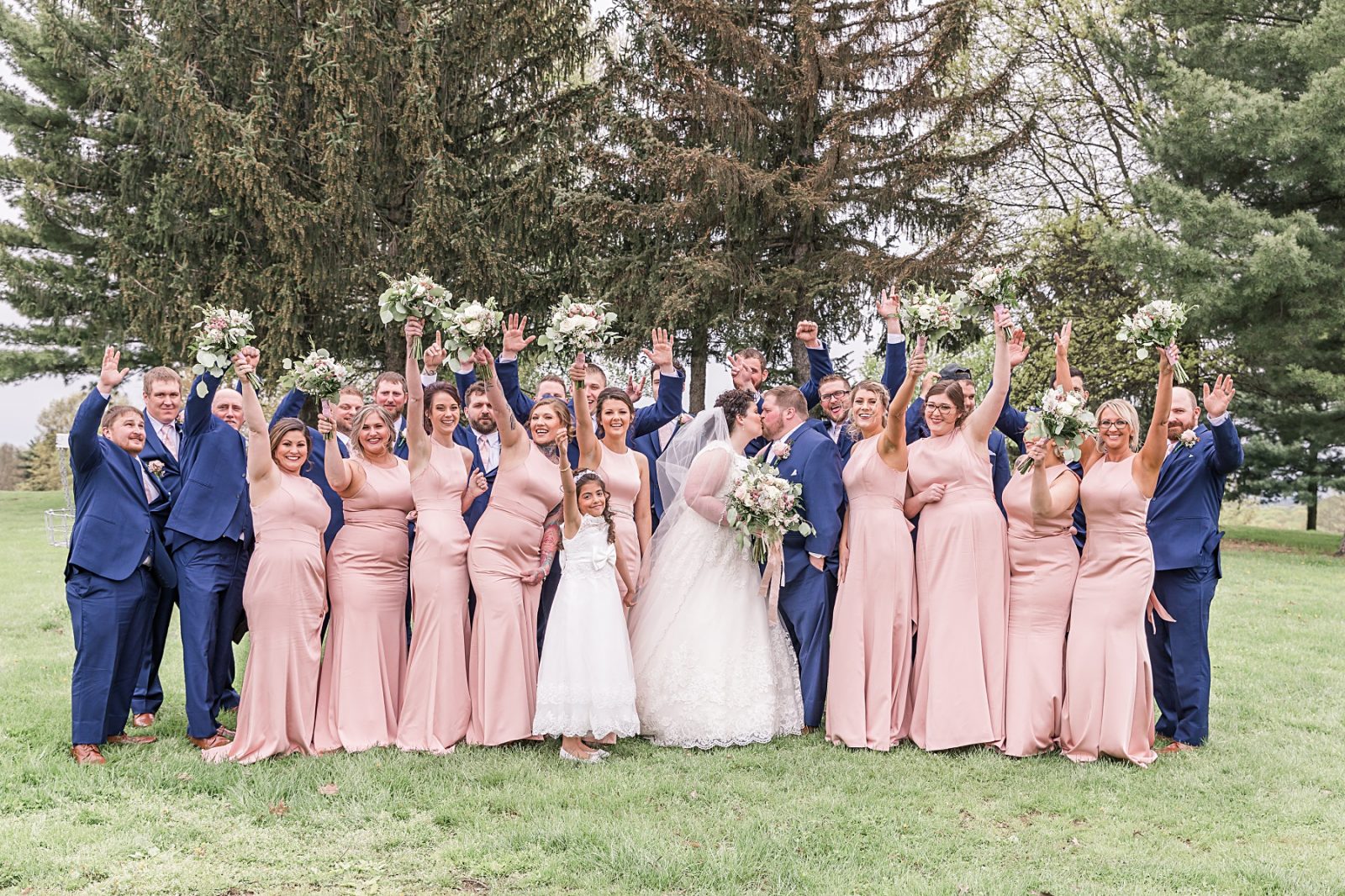 Wedding photography by Diana Gramlich, Blush and Navy Blue wedding party cheering while bride and groom kissing