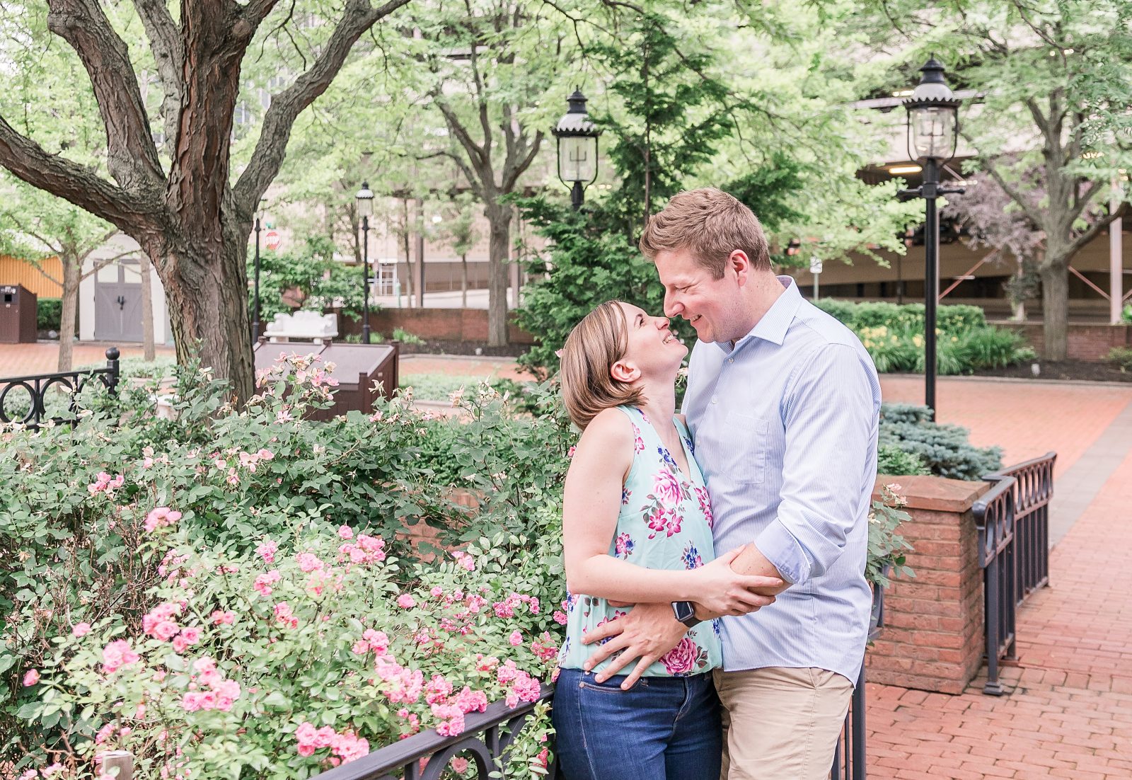 Engagement photos in downtown Canton, OH by Diana Gramlich Photography, Beautiful couple standing in the pretty flower garden facing each other and laughing