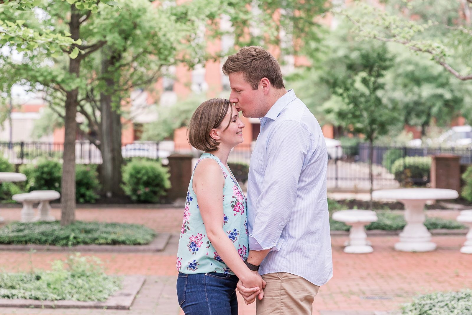 Engagement photos in downtown Canton, OH by Diana Gramlich Photography, couple in the garden facing each other and he is kissing her in the forehead