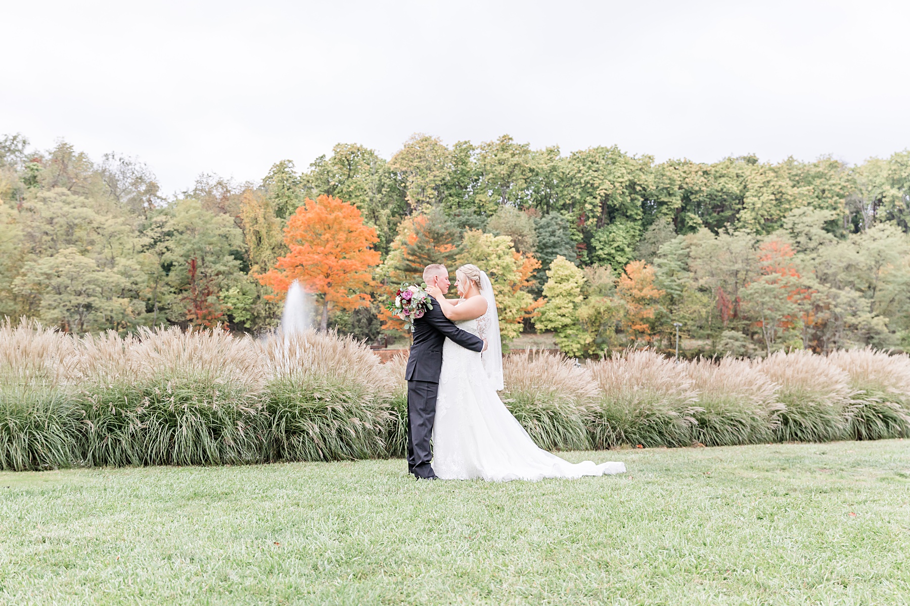 bride and groom looking at each other surrounded by fall foliage